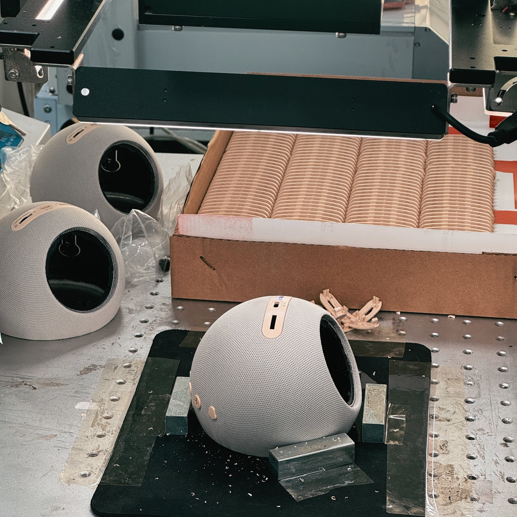 An automated machine performing high-precision drilling and processing on the white HOUSBAY MINI spherical housing.