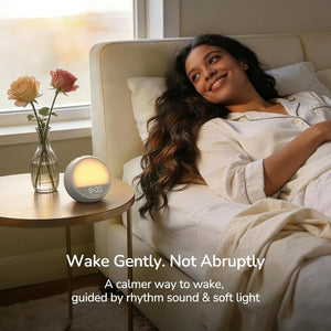 Woman waking up peacefully with the HOUSBAY Mini sunrise alarm clock in a calm bedroom