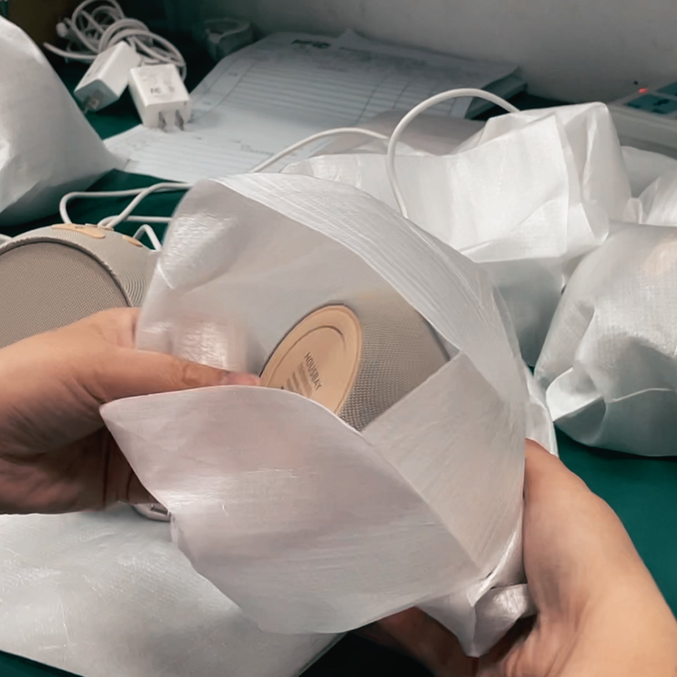 A worker carefully placing the finished product into a white protective foam pouch to prevent scratches during transport.