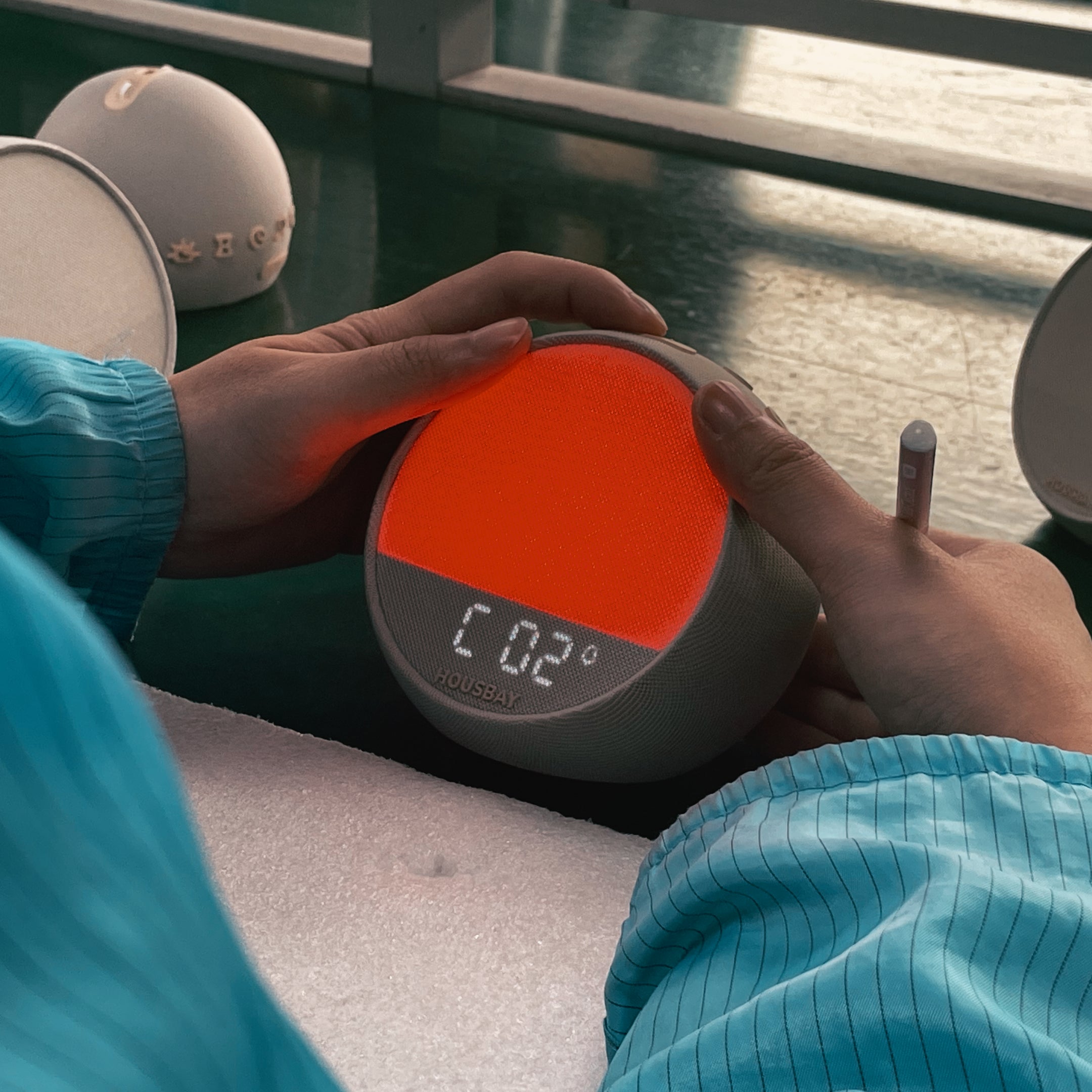 A quality inspector checking the screen display and activating the orange sunrise light for final product verification.