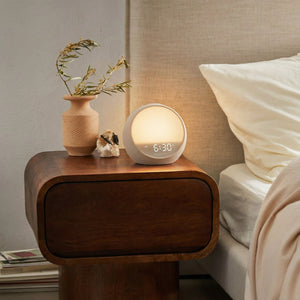 Sunrise alarm clock with gentle wake up light on bedside table